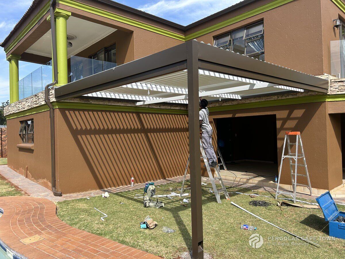 Bronze louvre roof at the Hermanus home seen from the garden during fitting.