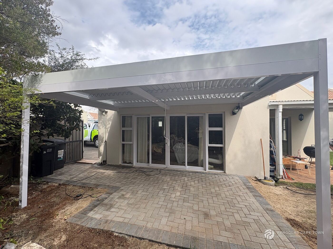 White-framed manual aluminium louvre roof over a Cape Town patio