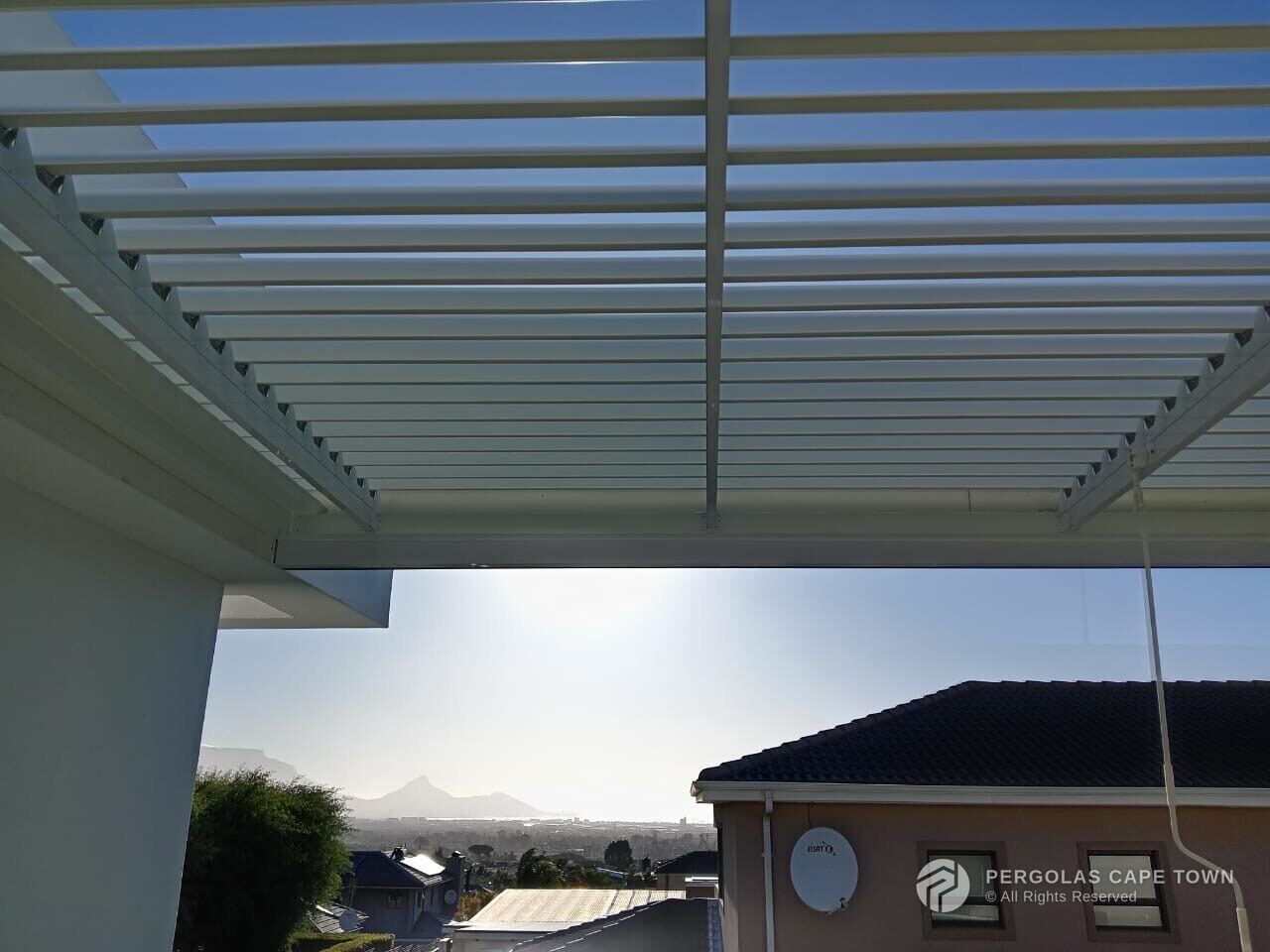Bronze aluminium louvre roof over a coastal patio — Hermanus, Western Cape