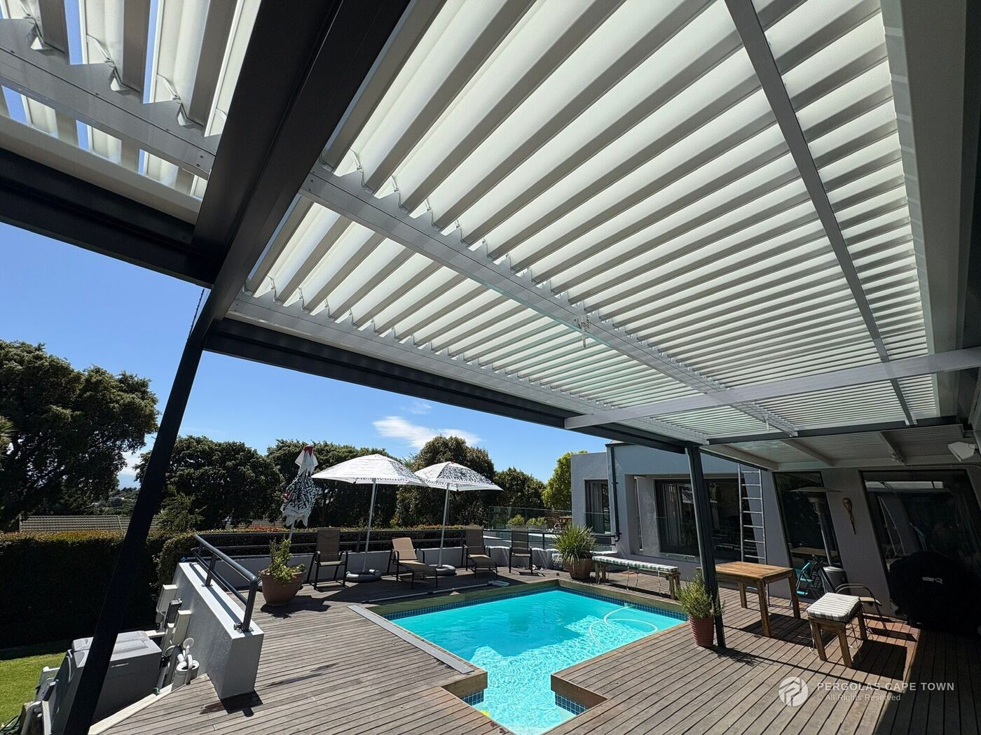Charcoal-framed, white-louvred aluminium roof over a patio — Blouberg, Cape Town
